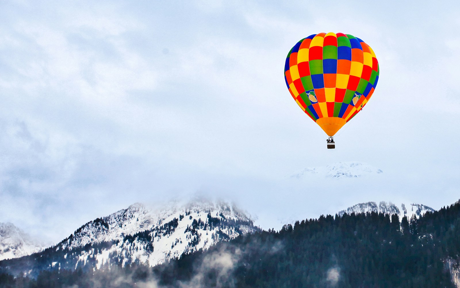 Hot air balloons over Château-d’Oex, Switzerland, with mountain backdrop.