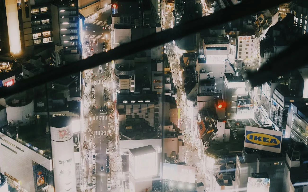 Aerial view of Shibuya at night with illuminated streets and buildings, Tokyo Guided Tour.