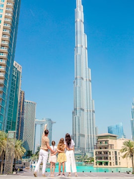Family admiring Burj Khalifa in Dubai with surrounding skyscrapers.