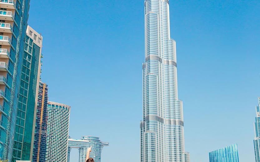 Family admiring Burj Khalifa in Dubai with surrounding skyscrapers.