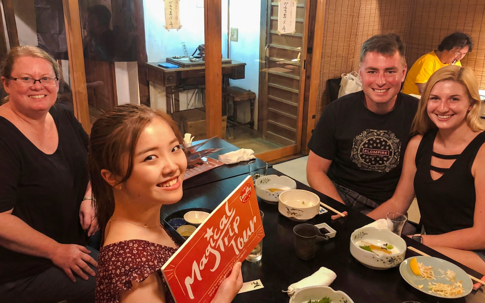 Group enjoying dinner on Kyoto Night Foodie Tour in traditional Japanese restaurant.