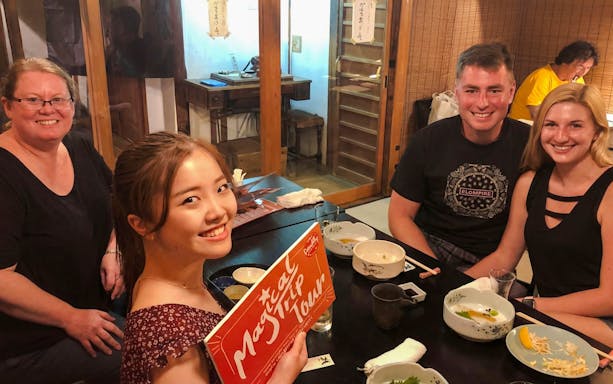 Group enjoying dinner on Kyoto Night Foodie Tour in traditional Japanese restaurant.