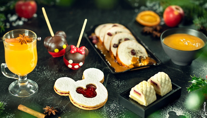 Disneyland Paris Christmas treats with Mickey-shaped cookie, chocolate apples, and festive desserts.