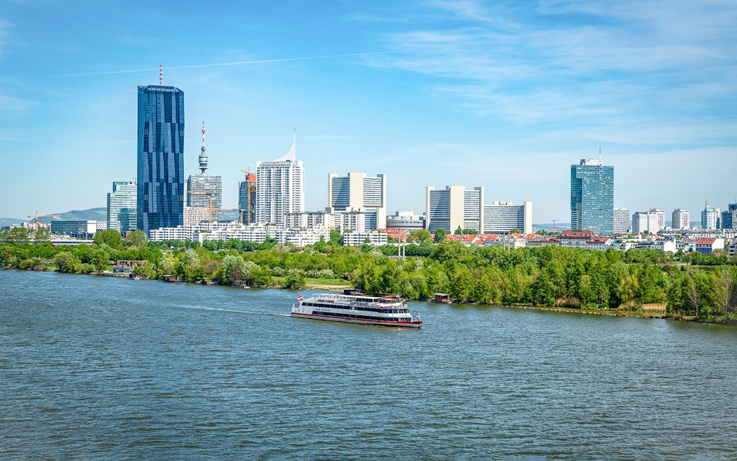 Cruise ship on the Danube River with Vienna skyline in the background.