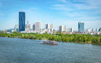 Cruise ship on the Danube River with Vienna skyline in the background.