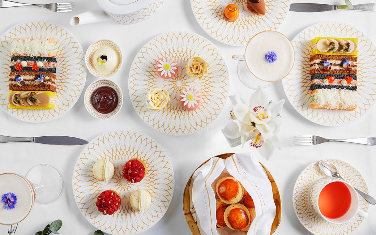 Platter of assorted delicacies at Pearl Afternoon Tea at Platos, featuring pastries and tea.