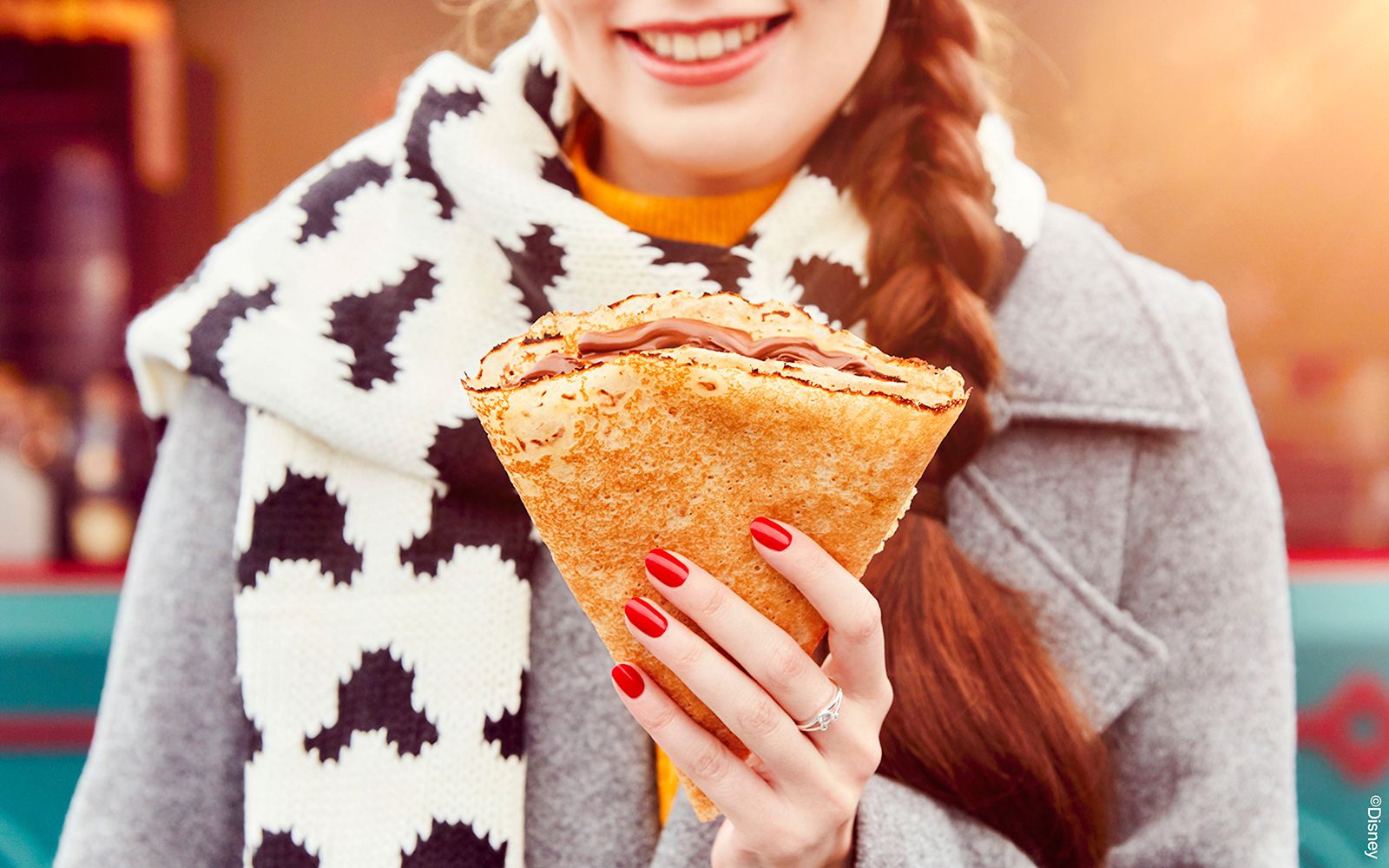 Person enjoying a crepe at Disneyland Paris during Christmas 2025.
