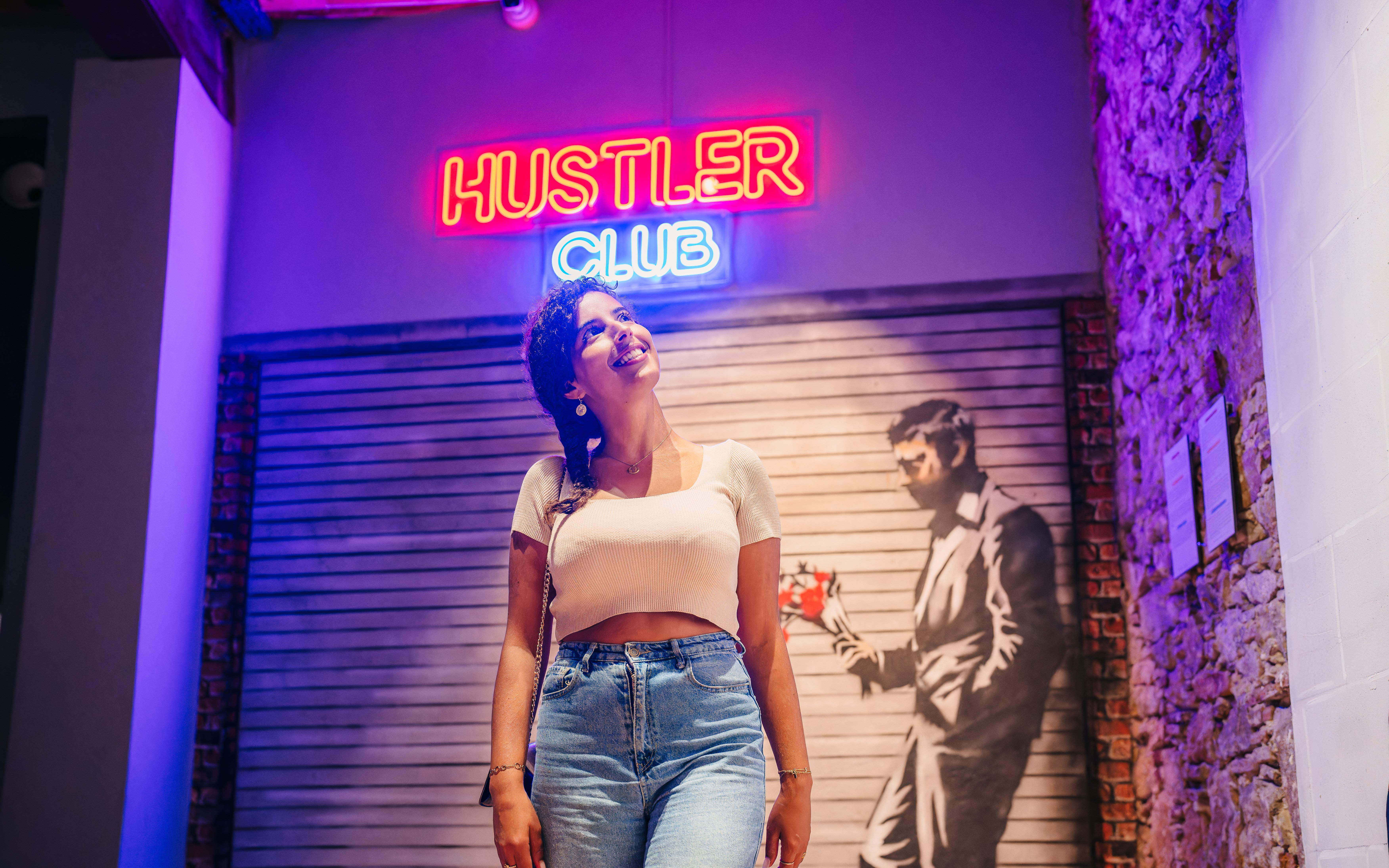 Tourist smiling at Banksy artwork in Barcelona museum.