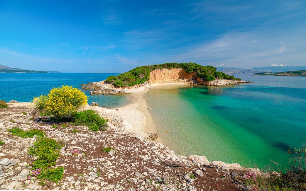 Ksamil Archipelago's Twin Islands with clear turquoise waters and rocky shoreline.
