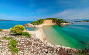 Ksamil Archipelago's Twin Islands with clear turquoise waters and rocky shoreline.