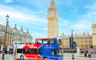 Golden Tours Hop-on Hop-off bus near Big Ben and Houses of Parliament, London.