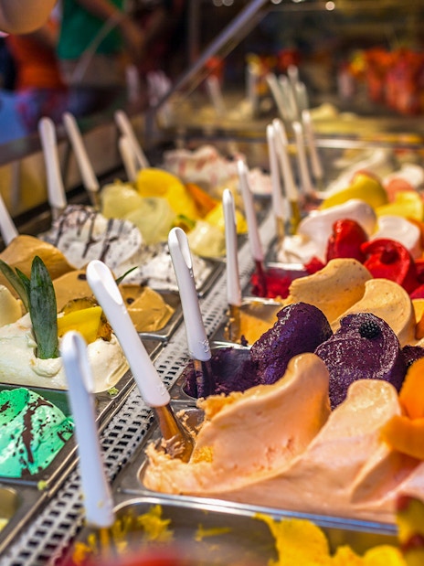 Gelato selection in Florence shop with various flavors and toppings.