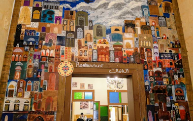 Colorful mural of As-Salt architecture above a restaurant entrance in Amman.