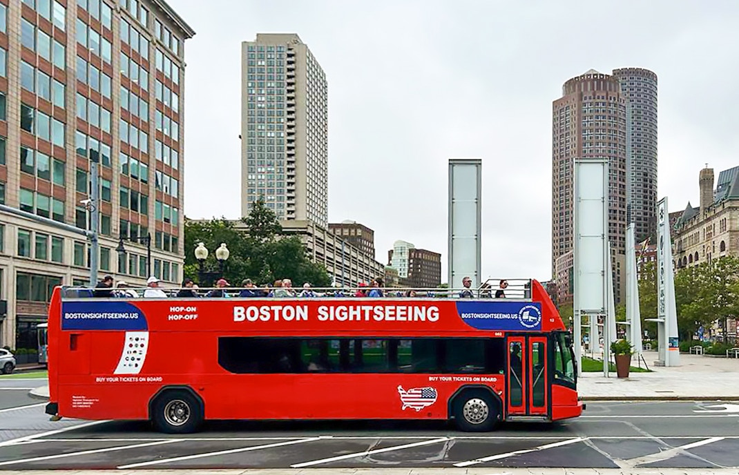 Boston sightseeing bus with Boston skyline in background