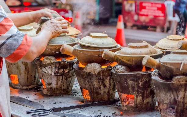 Claypot cooking on charcoal stoves during Kuala Lumpur nightlife food tour.