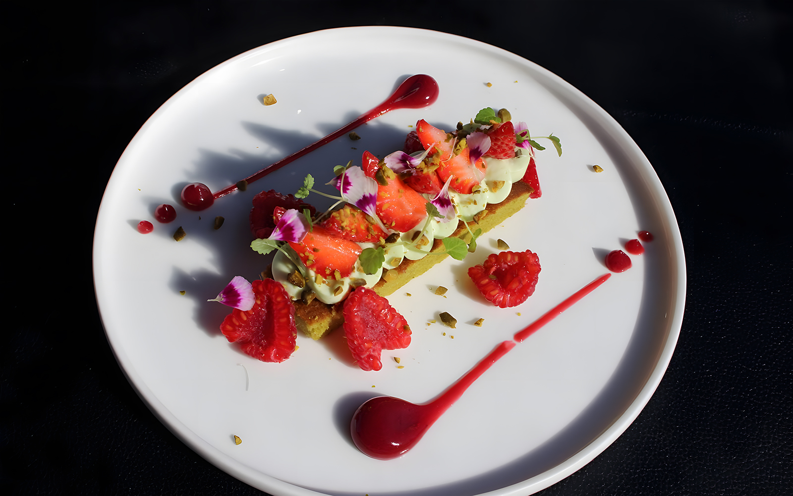 Strawberry and raspberry dessert with pistachio cream served on Bustronome Paris.