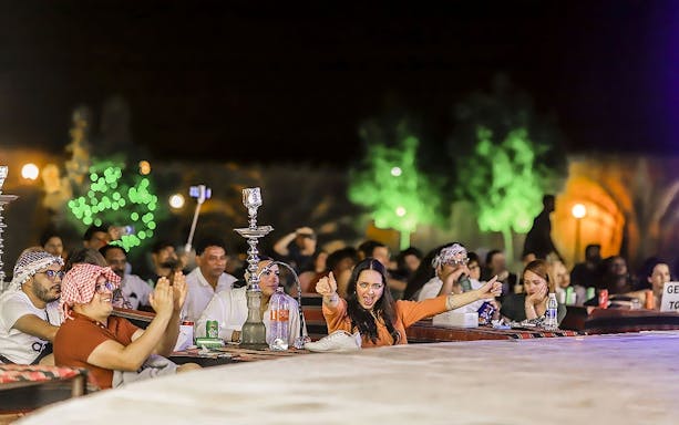 Guests enjoying an evening desert safari with BBQ dinner and shisha.