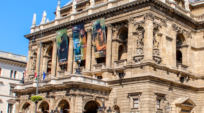 Facade of the Hungarian State Opera in Budapest with ornate architecture and street view.