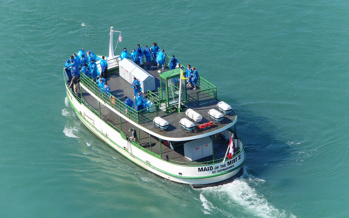 Aerial view of Maid of the Mist cruise boat with passengers in blue ponchos.