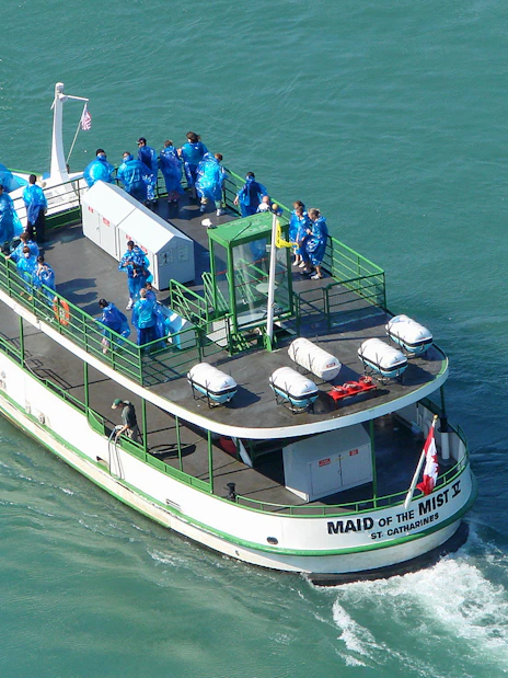 Aerial view of Maid of the Mist cruise boat with passengers in blue ponchos.