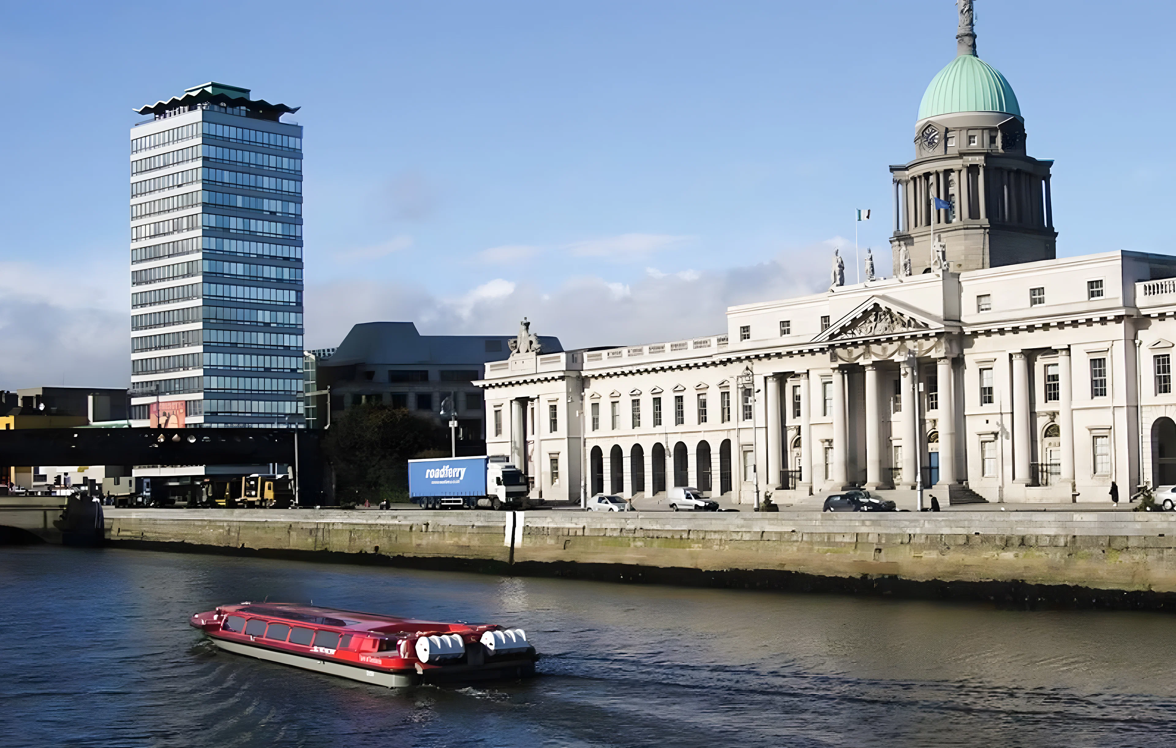 River cruise boat on the Liffey with Dublin's Custom House in the background.