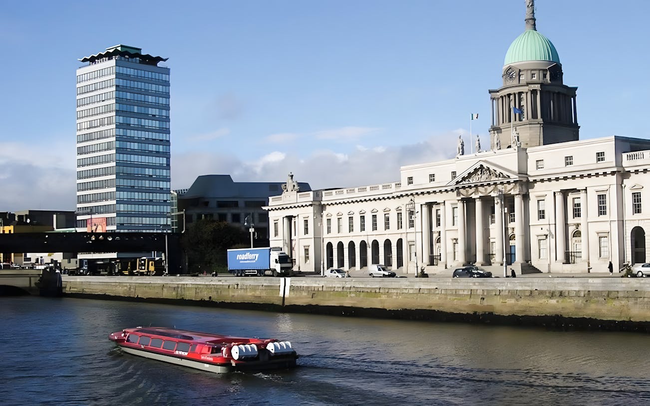 River cruise boat on the Liffey with Dublin's Custom House in the background.