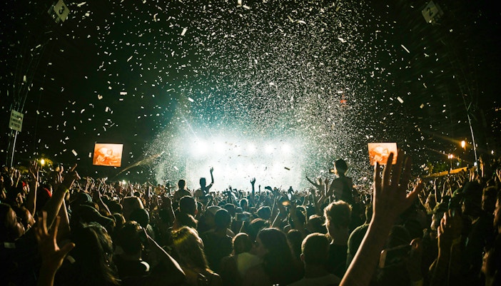 Crowd enjoying a night concert with confetti at Terra Solis by Tomorrowland.