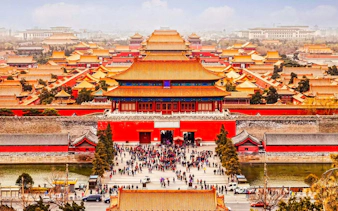 Elevated view of the Forbidden City in Beijing, China, with crowds and traditional architecture.
