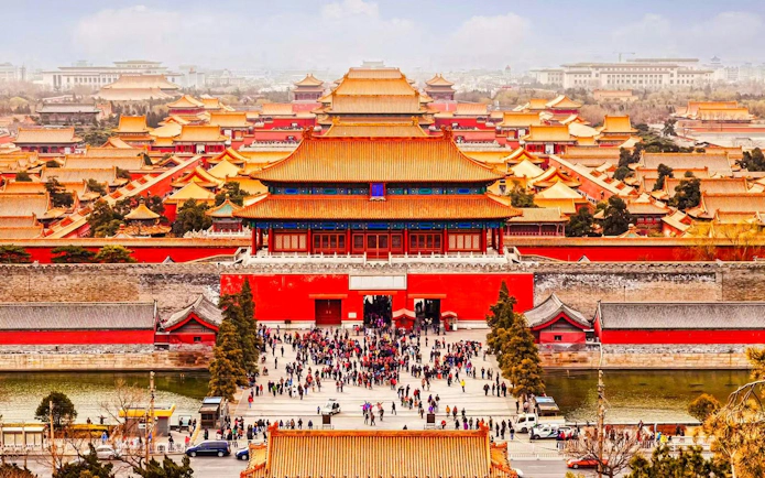 Elevated view of the Forbidden City in Beijing, China, with crowds and traditional architecture.