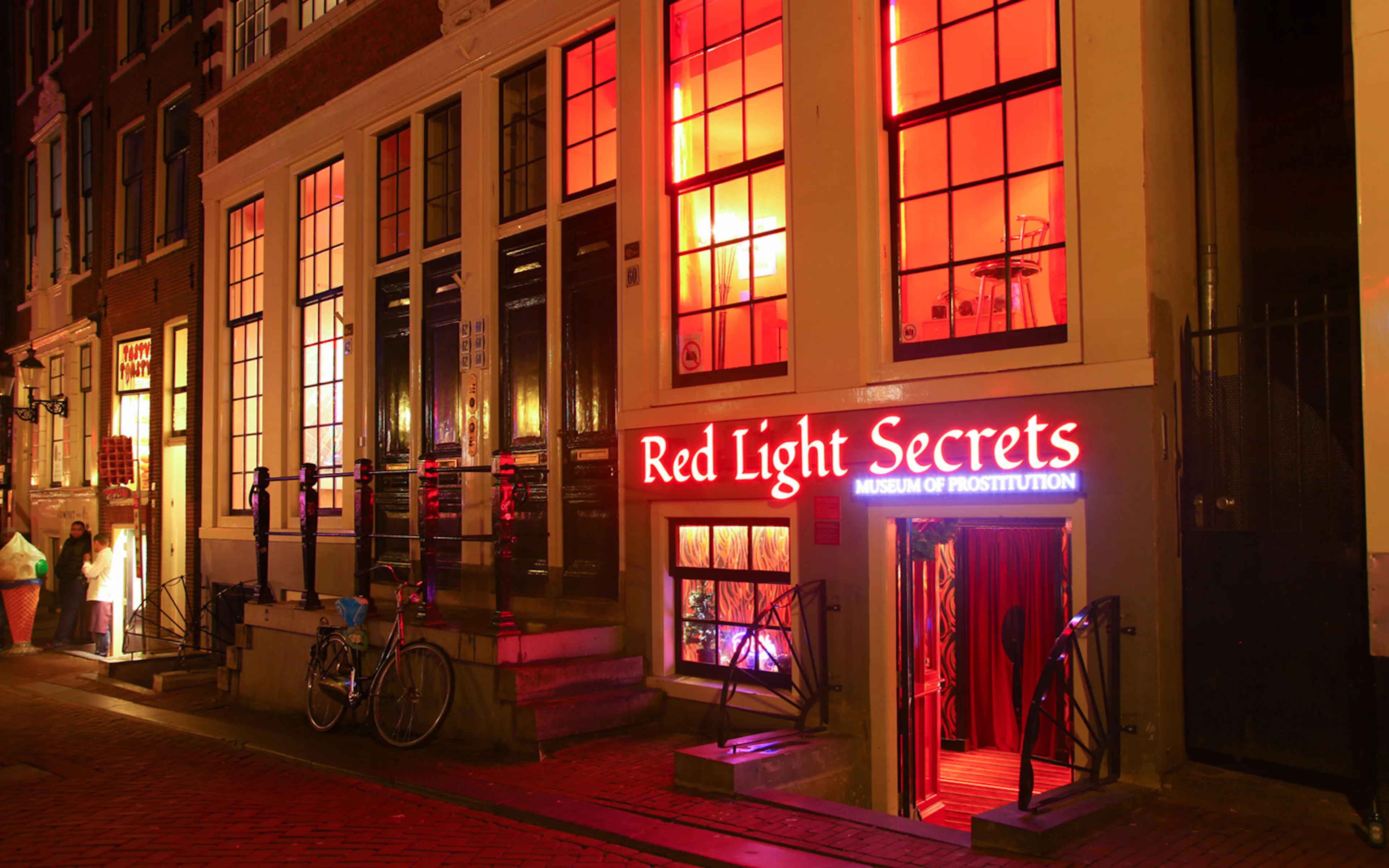 Red Light Secrets Museum entrance in Amsterdam's Red Light District at night.