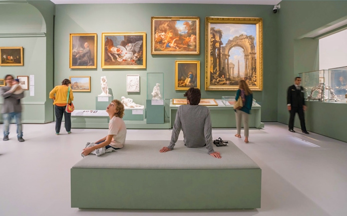 Tourists exploring art exhibits at the Louvre Museum Abu Dhabi.