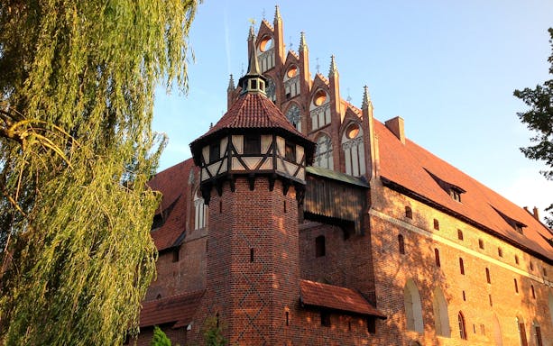 Malbork Castle's Gothic architecture with red brick walls and spires, Poland.