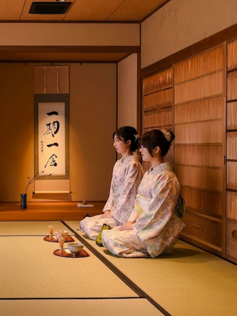 Kimono-clad women participating in a tea ceremony at a traditional Japanese house.