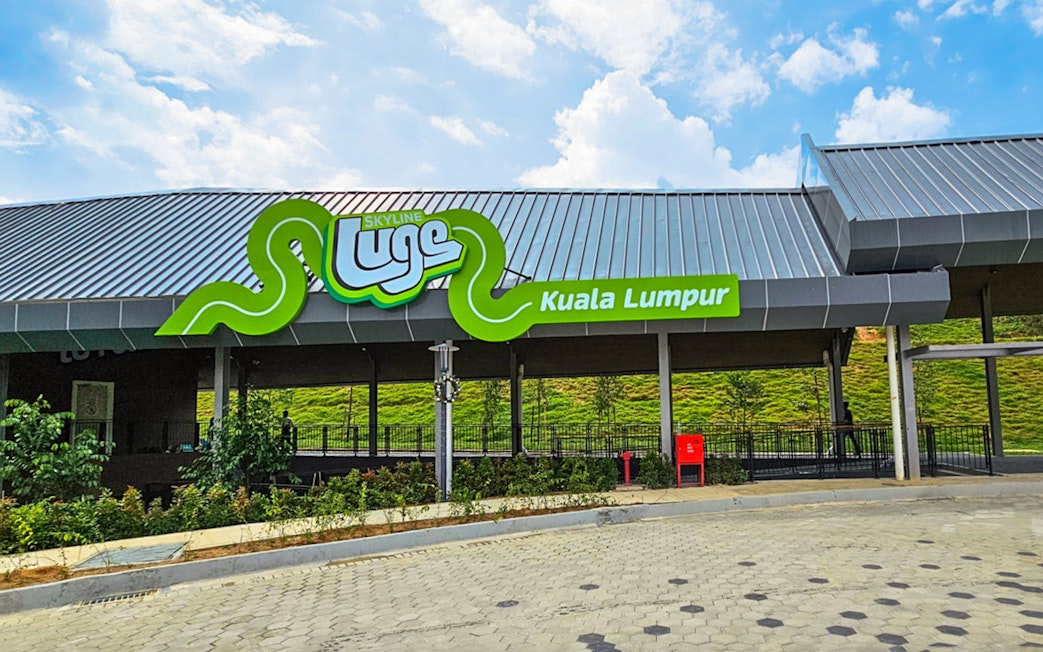 Skyline Luge Kuala Lumpur entrance with green signage and modern architecture.