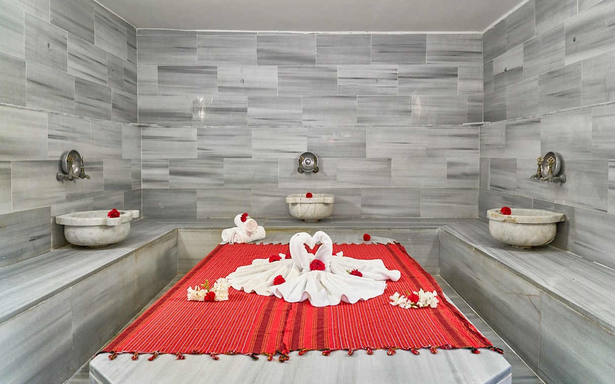 Private historical hammam bath setup with towels and flowers in Cappadocia, Turkey.