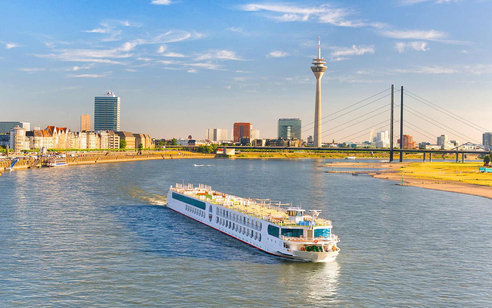 Cruise ship on the Rhine River with Dusseldorf TV Tower in the background.