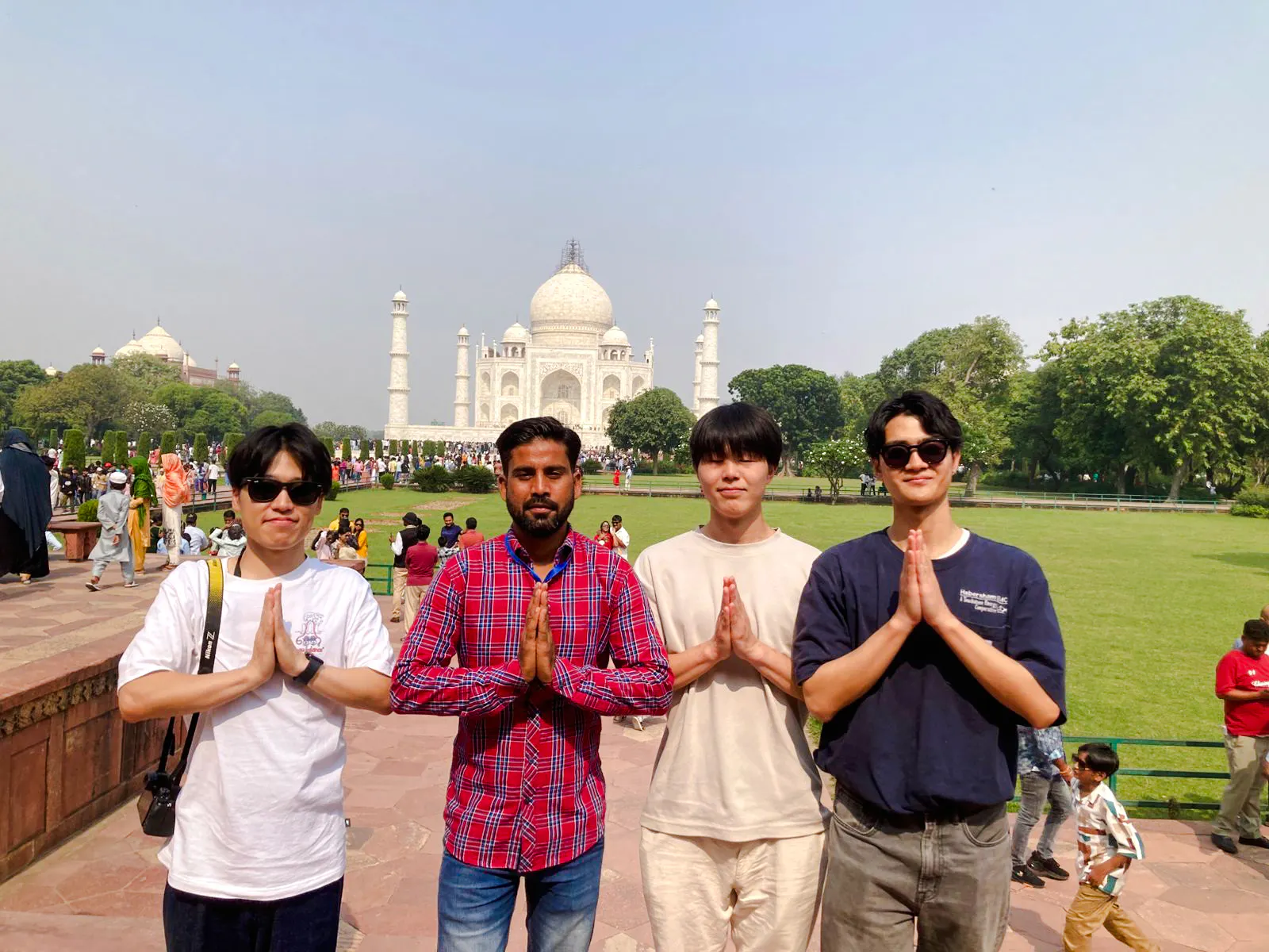 Visitors posing in front of the Taj Mahal during the Agra tour from Delhi.