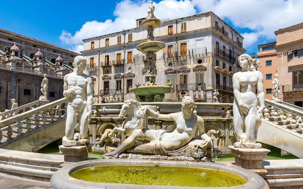 Fontana Pretoria in Palermo with statues and historic buildings in the background.