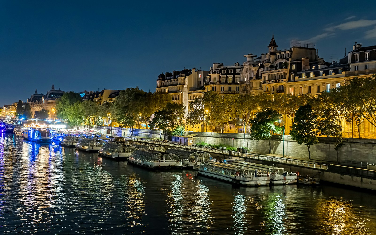 Seine River cruise at night with illuminated Eiffel Tower in Paris.