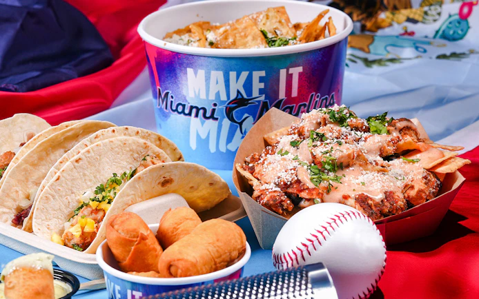 Tacos, nachos, and snacks with Miami Marlins branding at a baseball-themed event.