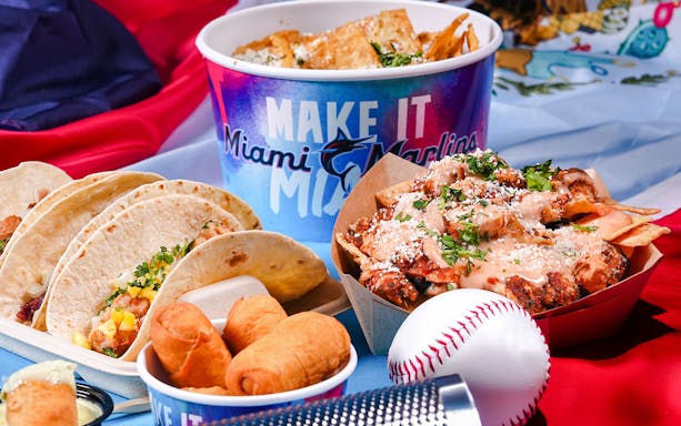 Tacos, nachos, and snacks with Miami Marlins branding at a baseball-themed event.
