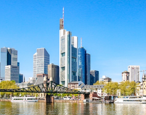 Frankfurt skyline with skyscrapers and Eiserner Steg bridge over the Main River.