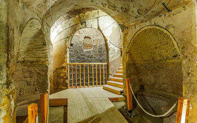 Ancient stone chamber with arched ceilings and wooden stairs in Cairo.