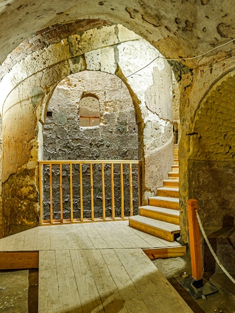 Ancient stone chamber with arched ceilings and wooden stairs in Cairo.