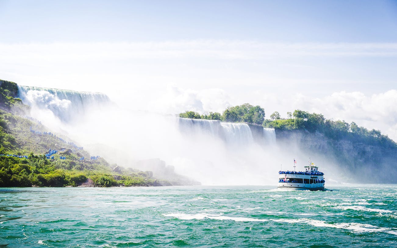 Maid of the Mist boat approaching Niagara Falls, USA, with mist rising from the waterfall.