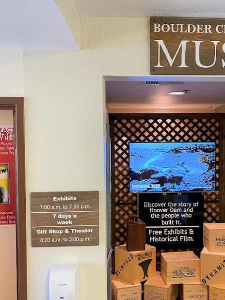 Boulder City Hoover Dam Museum entrance with exhibit hours and historical film display.
