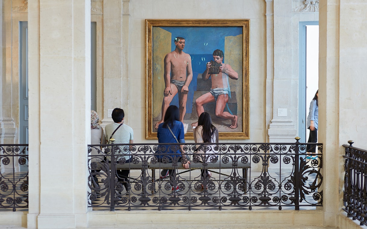 Visitors viewing a large painting in a museum gallery.