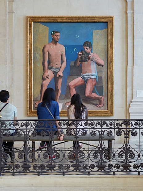 Visitors viewing a large painting in a museum gallery.