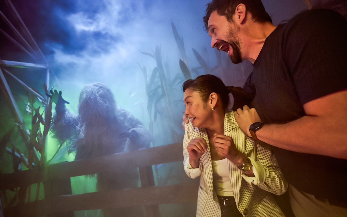 Guests react to a costumed creature at Universal Horror Unleashed in Las Vegas.