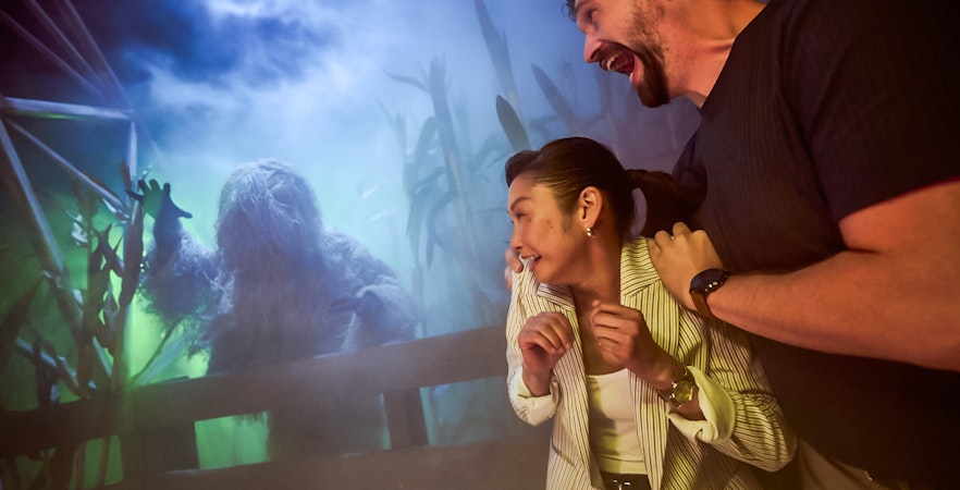 Guests react to a costumed creature at Universal Horror Unleashed in Las Vegas.